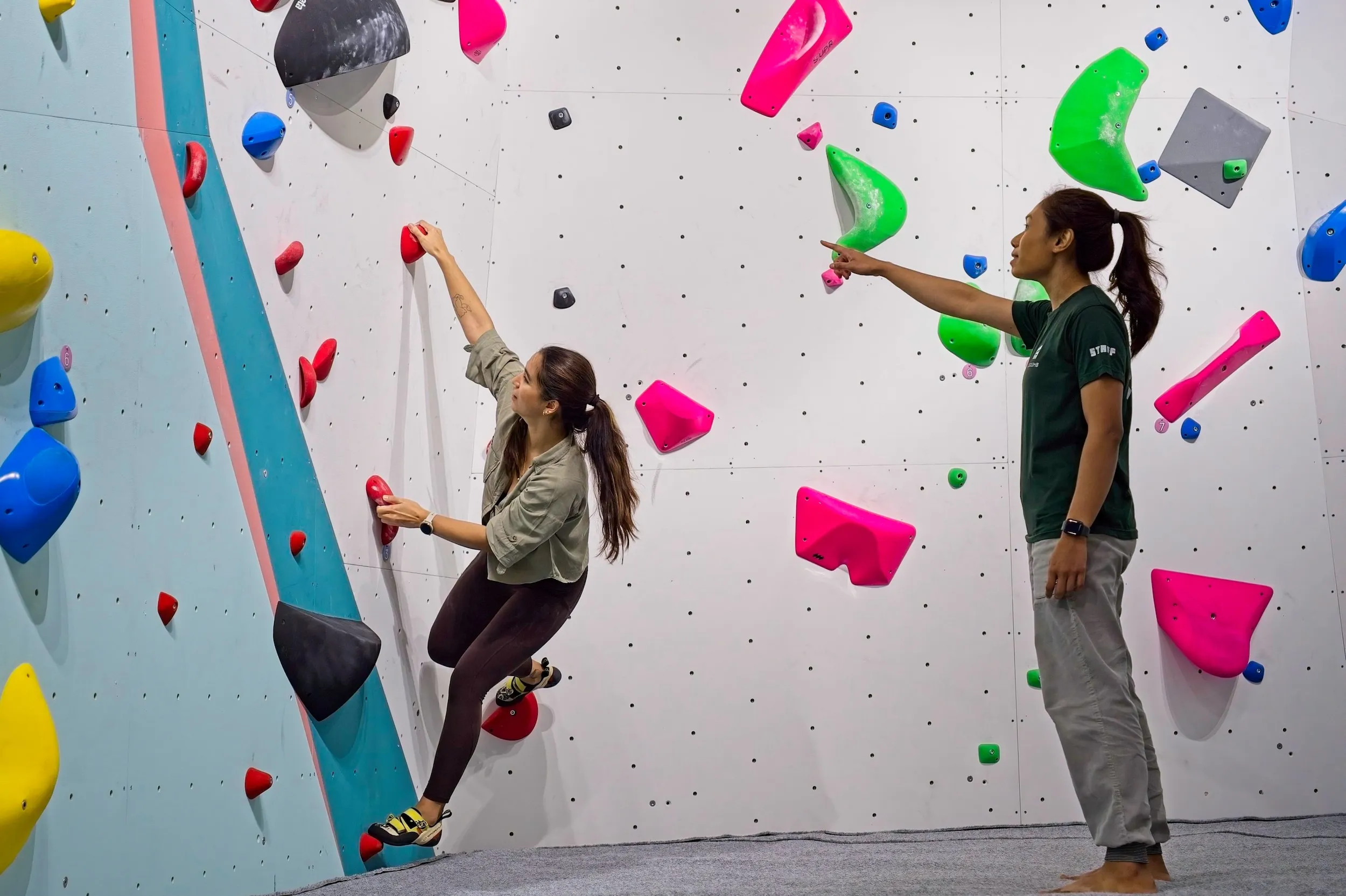 Coach guiding a climber through their intro session