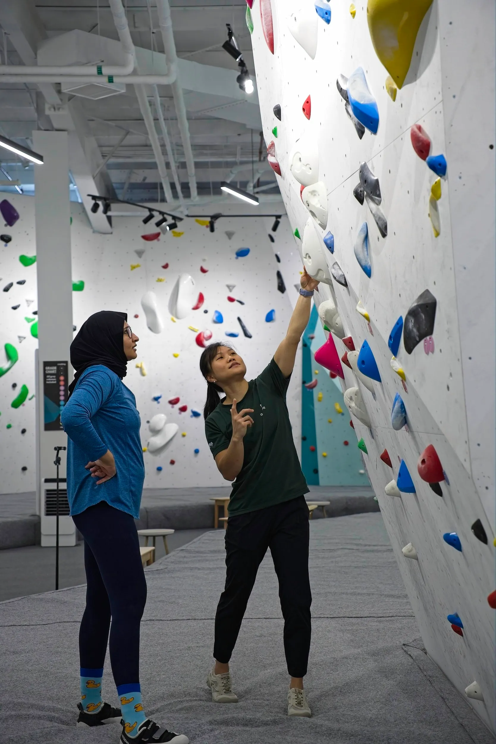 A coach teaching technique to a class of climbers.