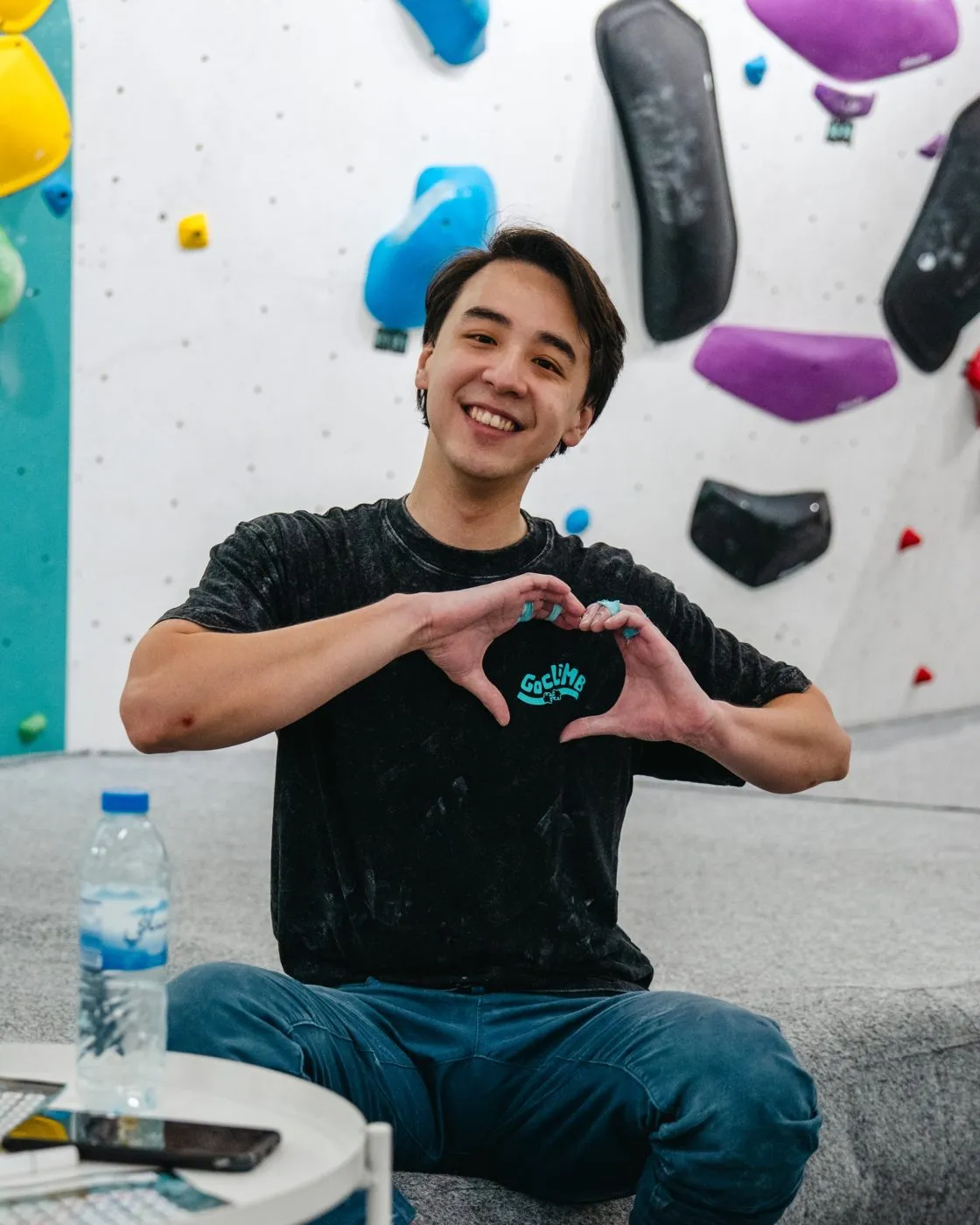 A smiling climber making a heart with his hands